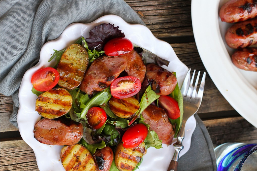 Saucisses et pommes de terre grillées avec salade mixte verte